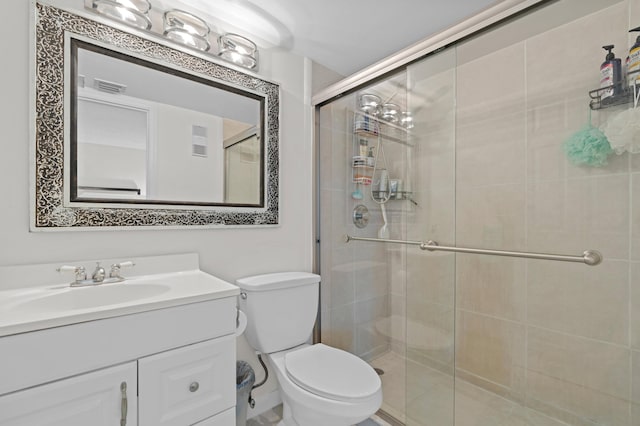 bathroom featuring vanity, an enclosed shower, and toilet