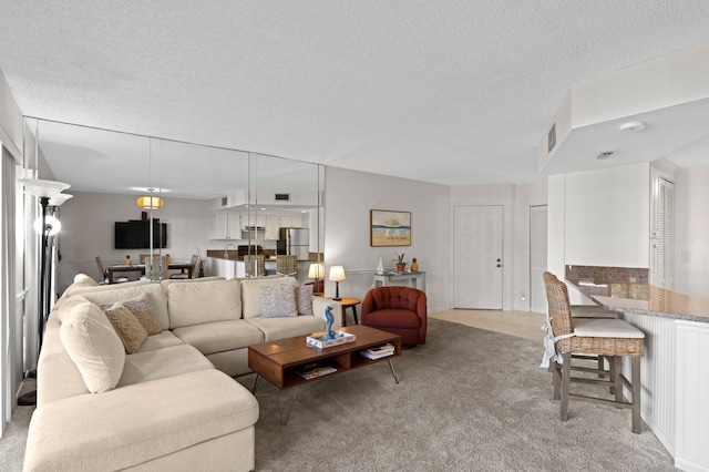 living room featuring light colored carpet and a textured ceiling