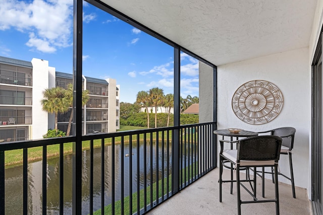 sunroom featuring a water view