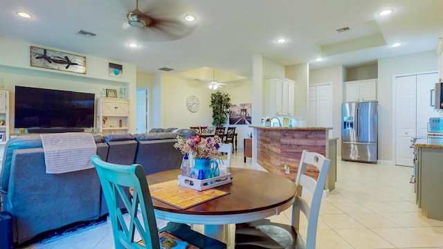 tiled dining space with ceiling fan