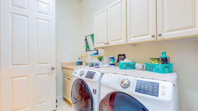 clothes washing area with light tile patterned flooring, cabinets, independent washer and dryer, and sink