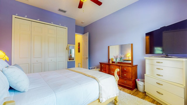 bedroom with ceiling fan, light wood-type flooring, and a closet