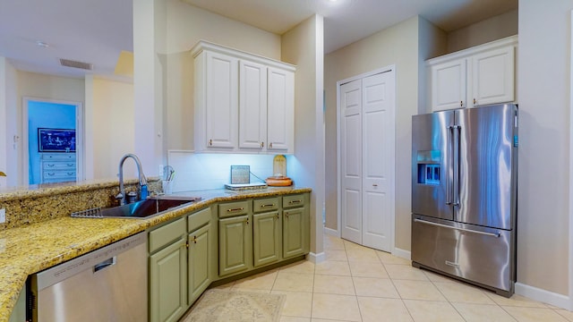 kitchen featuring white cabinets, light stone counters, sink, and appliances with stainless steel finishes