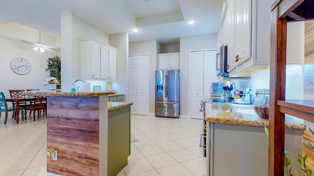 kitchen featuring white cabinets, stainless steel fridge with ice dispenser, ceiling fan, and light tile patterned flooring