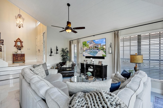 living room featuring ceiling fan with notable chandelier and vaulted ceiling