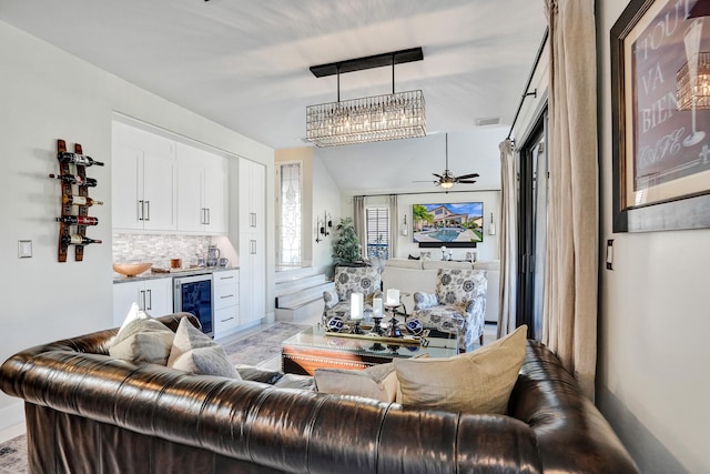 living room featuring ceiling fan, beverage cooler, and bar area