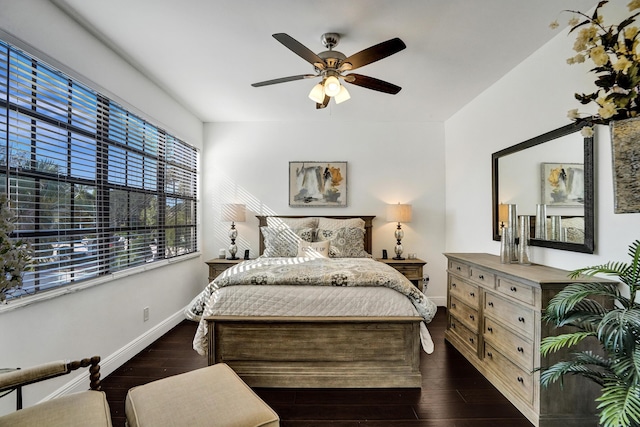 bedroom featuring ceiling fan, dark wood-type flooring, and multiple windows