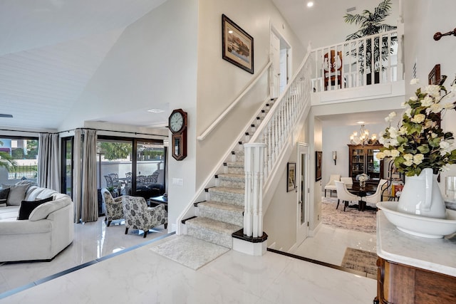 stairway featuring high vaulted ceiling and a notable chandelier