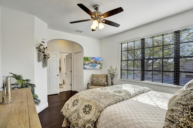 bedroom with ensuite bath, ceiling fan, and dark wood-type flooring