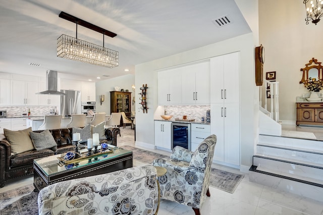 living room featuring wine cooler and an inviting chandelier