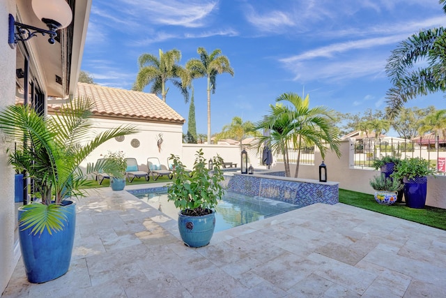 view of swimming pool featuring pool water feature and a patio