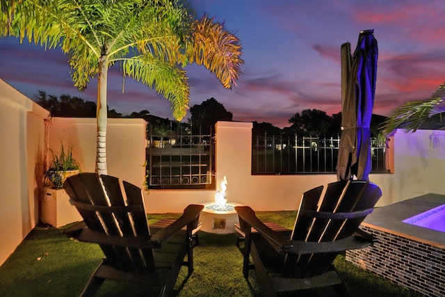 patio terrace at dusk featuring an outdoor fire pit