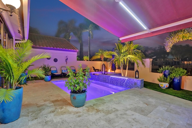 pool at dusk featuring a patio area