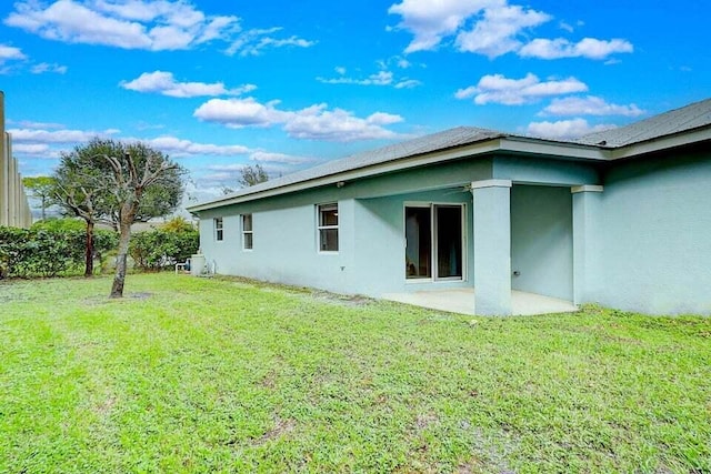 back of house featuring a patio area and a yard