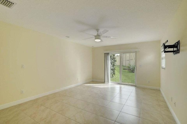 tiled empty room with a textured ceiling and ceiling fan