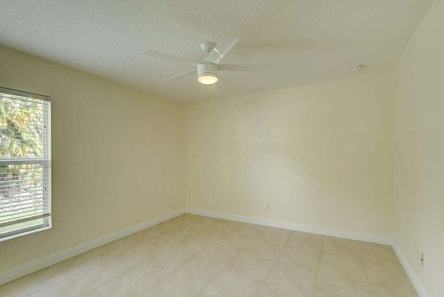 empty room with plenty of natural light, ceiling fan, and a textured ceiling