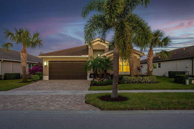 view of front of house with a garage and a lawn