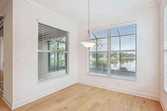 unfurnished dining area with hardwood / wood-style flooring and crown molding