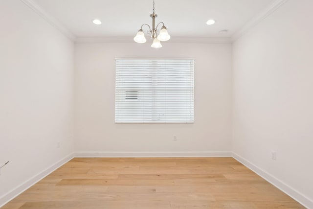 empty room with an inviting chandelier, ornamental molding, and light hardwood / wood-style flooring