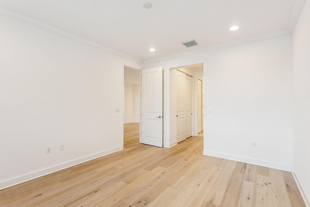 spare room featuring crown molding and light hardwood / wood-style floors