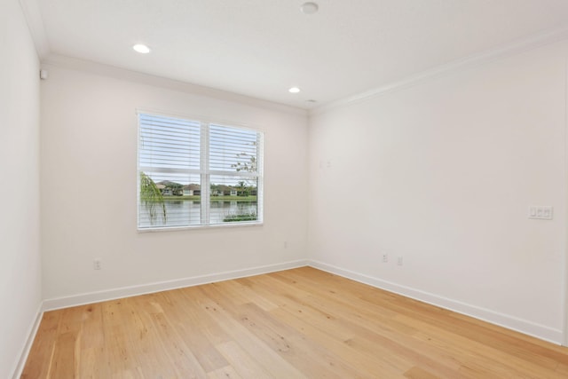 unfurnished room featuring ornamental molding, a water view, and wood-type flooring