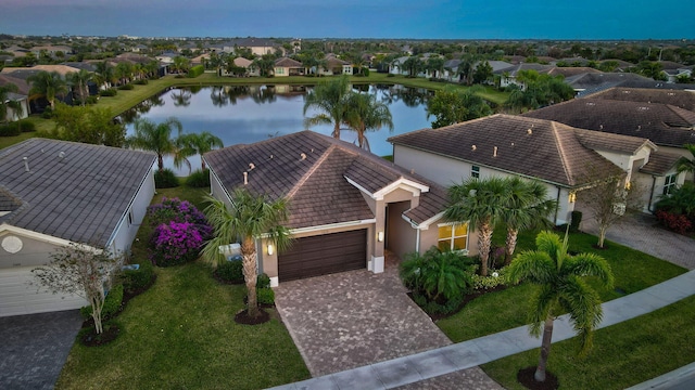 aerial view at dusk featuring a water view