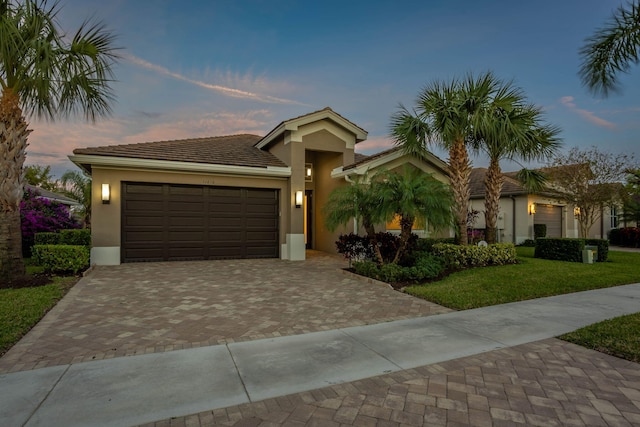 view of front of home featuring a garage and a yard