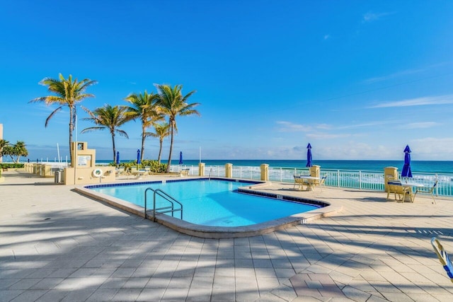 view of swimming pool with a water view and a patio