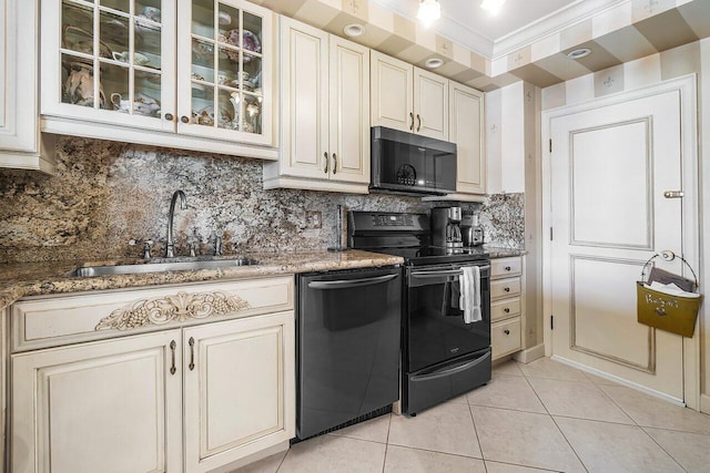 kitchen featuring sink, dark stone counters, decorative backsplash, light tile patterned floors, and black appliances