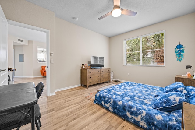 bedroom with wood-type flooring, ceiling fan, and a textured ceiling