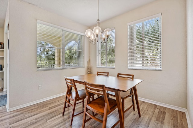 dining space featuring light hardwood / wood-style floors and a notable chandelier