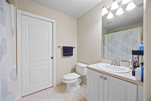 bathroom with vanity, a textured ceiling, tile patterned floors, and toilet