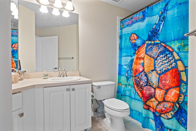 bathroom featuring tile patterned floors, vanity, toilet, and a textured ceiling