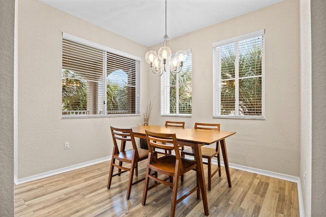 dining area with a notable chandelier and light wood-type flooring