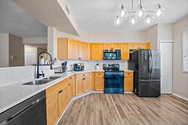 kitchen with dishwashing machine, sink, range with electric stovetop, black fridge, and decorative light fixtures