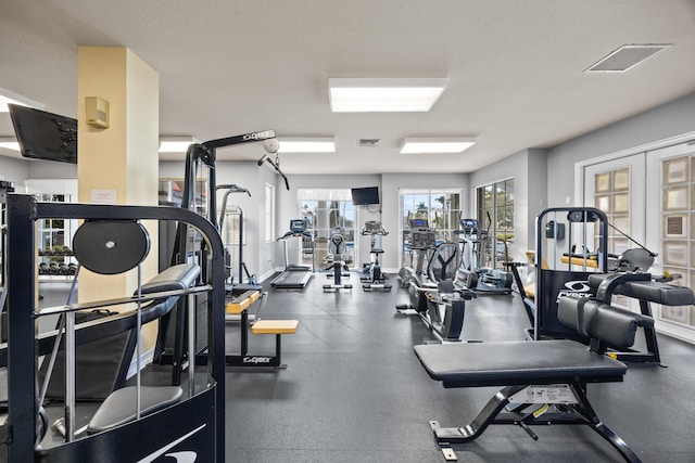 gym with french doors and a textured ceiling