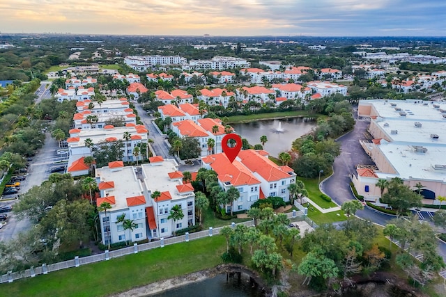 aerial view at dusk featuring a water view