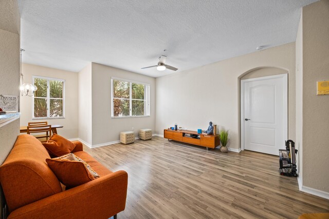 living room featuring ceiling fan, hardwood / wood-style floors, and a textured ceiling