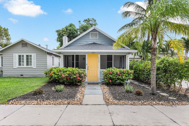 bungalow-style home featuring a front yard and a sunroom