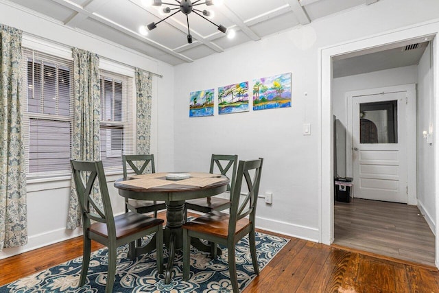 dining area with coffered ceiling, an inviting chandelier, and dark hardwood / wood-style floors