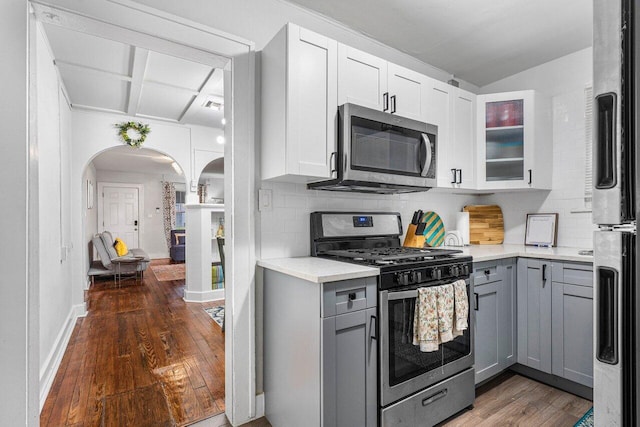 kitchen with dark wood-type flooring, appliances with stainless steel finishes, backsplash, and gray cabinetry