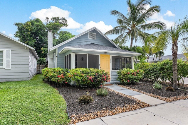 view of front facade featuring a front yard and a sunroom