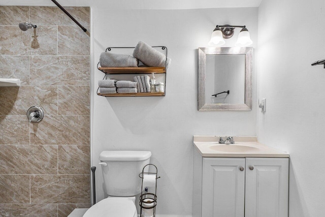 bathroom featuring toilet, a tile shower, and vanity