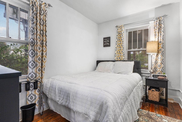 bedroom featuring multiple windows and dark wood-type flooring