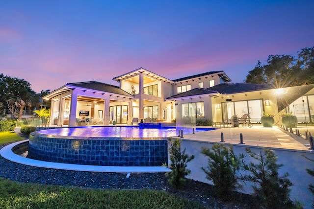 back house at dusk featuring a patio