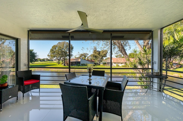 sunroom featuring a water view