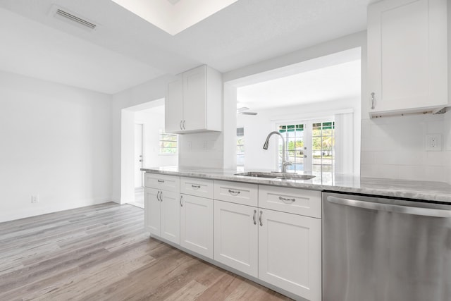 kitchen with white cabinetry, dishwasher, light stone countertops, sink, and light hardwood / wood-style flooring