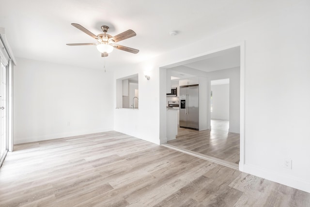 spare room featuring ceiling fan, light hardwood / wood-style flooring, and sink