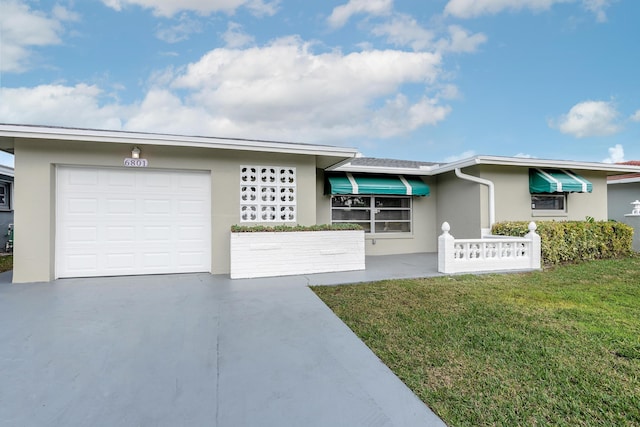 ranch-style home featuring a front lawn and a garage