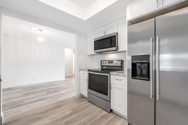 kitchen featuring decorative backsplash, white cabinetry, stainless steel appliances, and light hardwood / wood-style flooring